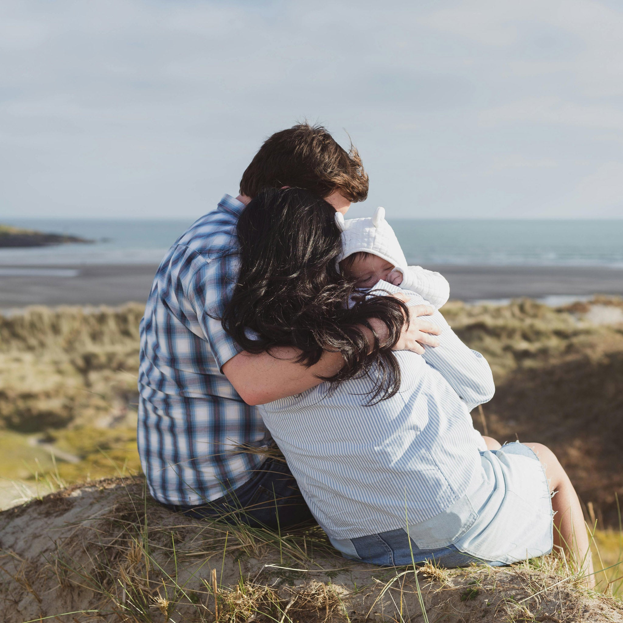 Reisen mit Baby: Paar mit Baby im Arm