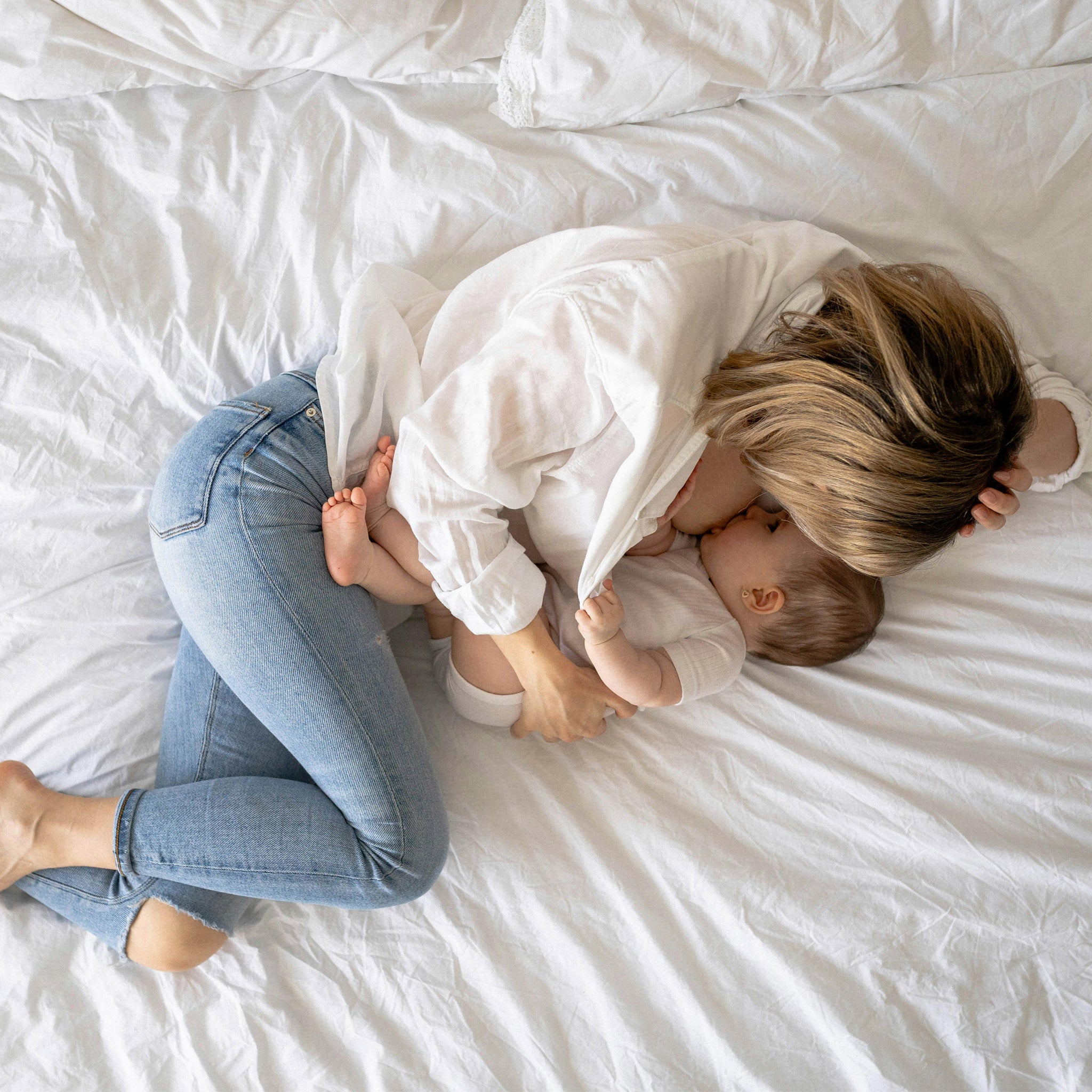 Mutter stillt ihr Kind im Bett